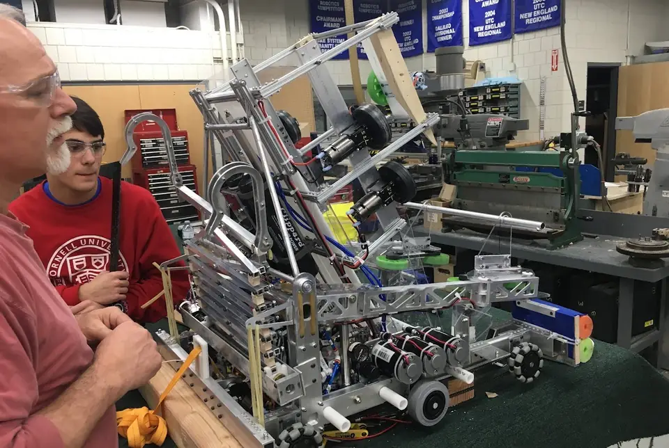 Team members beside a FIRST Robotics Team 236 robot.