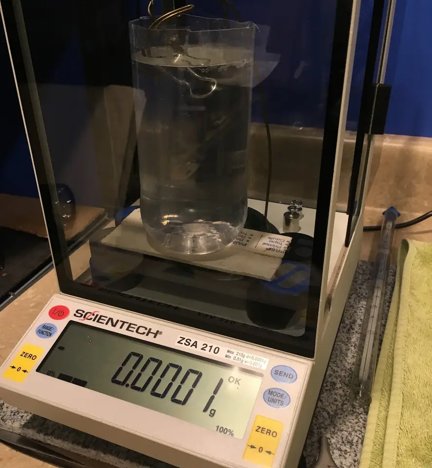 Water-displacement density rig on a laboratory balance.