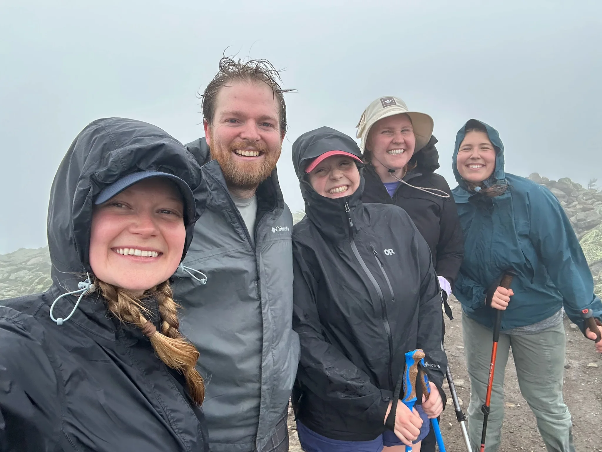 A group of hikers on a misty rocky summit.
