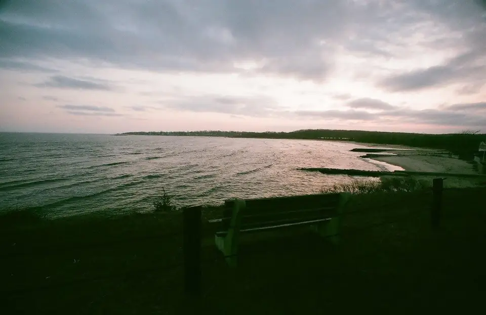 Water and a distant shoreline beneath a cloudy sky.