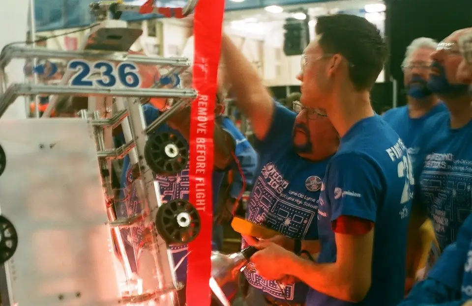 A student working beside a robot marked 236.