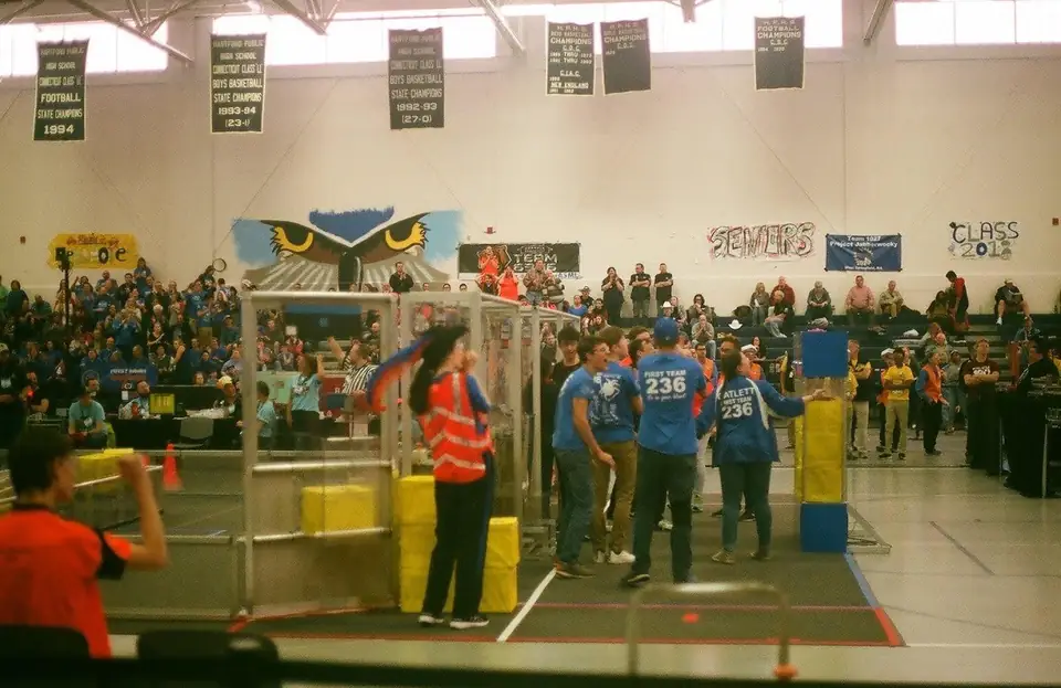 A robotics team beside a competition field.