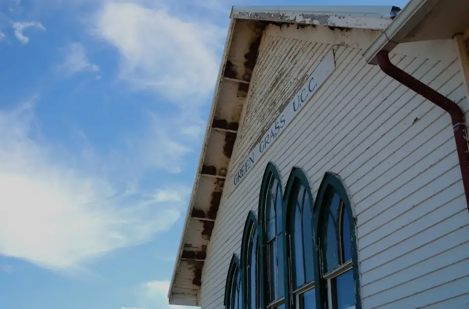 A white building with arched windows beneath a blue sky.