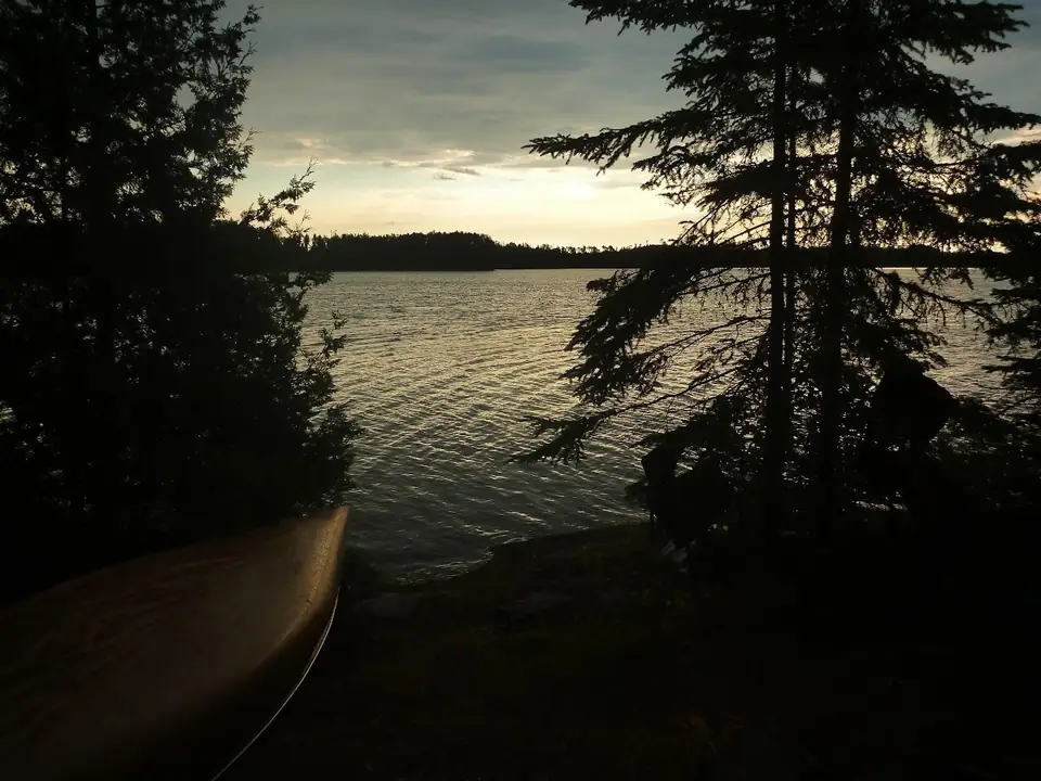 A lake framed by trees at dusk.