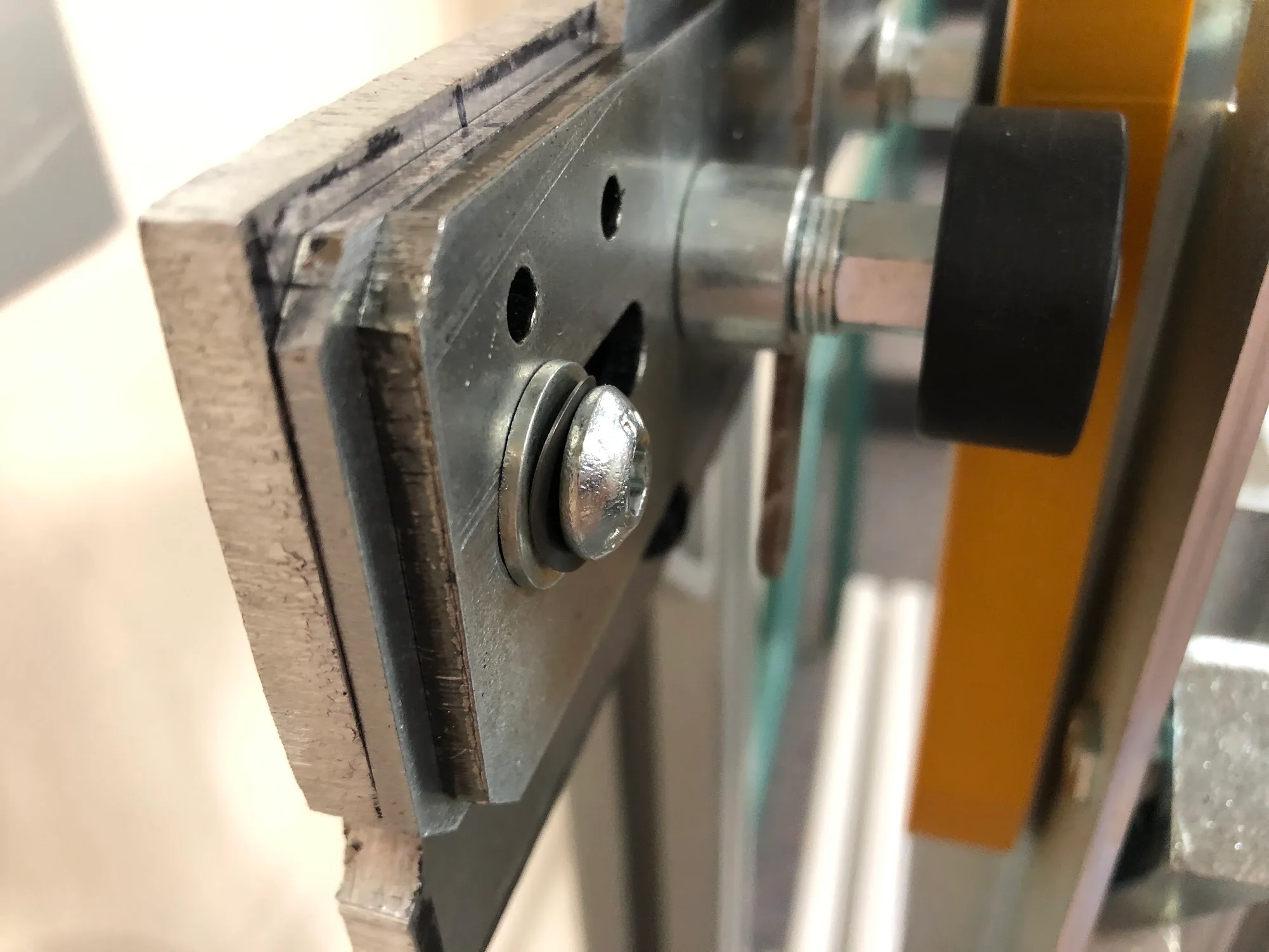Close-up of the interlock roller, slotted mounting plate and yellow alignment guide.