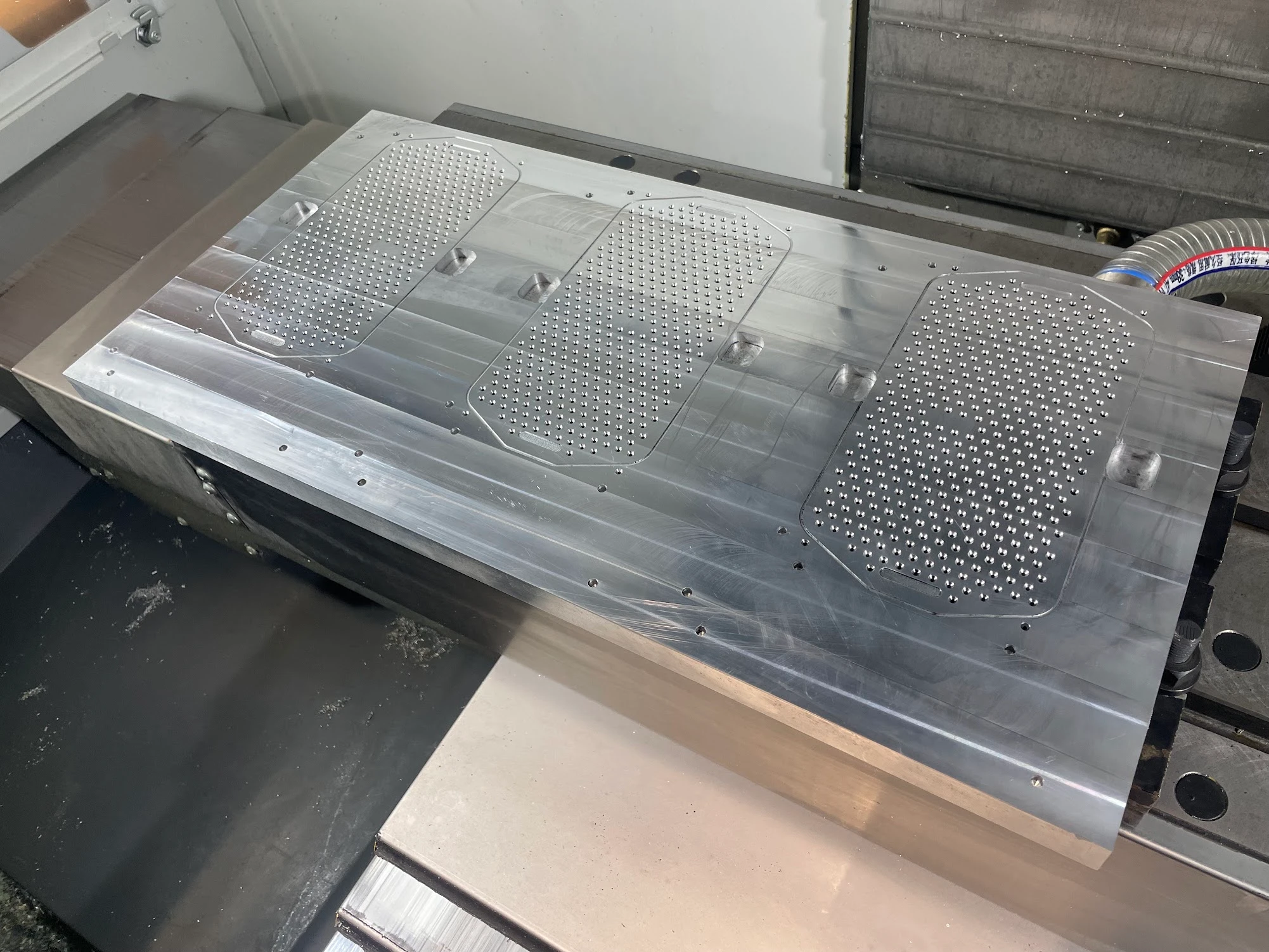 Custom machined vacuum chuck fixture inside the Haas VF-2